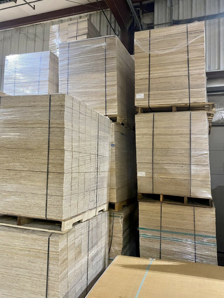 Plywood and particle board panel products stacked in Lakeland Pallets Indiana warehouse